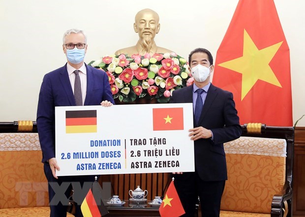 Deputy Minister of Foreign Affairs To Anh Dung (R) receives a token of the vaccine from German Ambassador to Vietnam Guido Hildner at the ceremony (Photo: VNA)