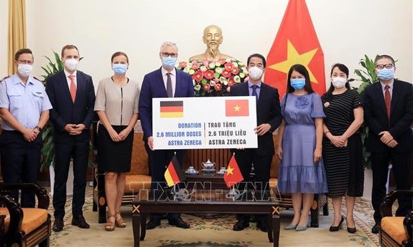 Deputy Minister of Foreign Affairs To Anh Dung (fourth, right) symbolically receives 2.6 million AstraZeneca COVID-19 vaccine from German Abassador to Vietnam Guido Hildner. (Photo: VNA)