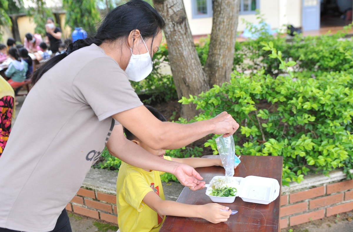 Các em học sinh được mẹ chăm sóc trong khu vực cách ly. 