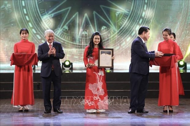 A representative of the group of authors from VNA's Department of Domestic News receives a first prize. (Photo: VNA)