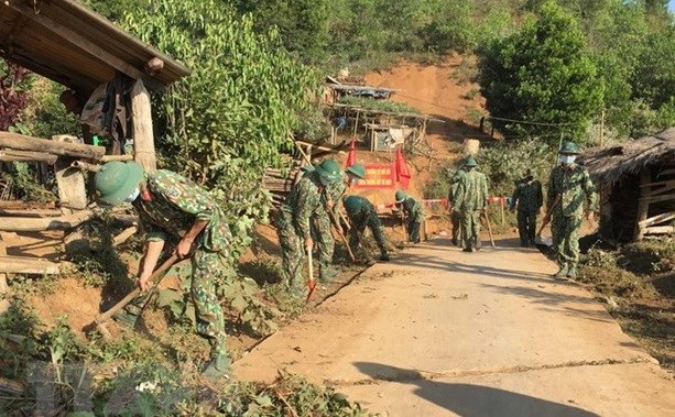 Soldiers of the infantry battalion (Regiment 741, the Military Command of Dien Bien province)  help clean up an inter-village road (Photo: VNA)