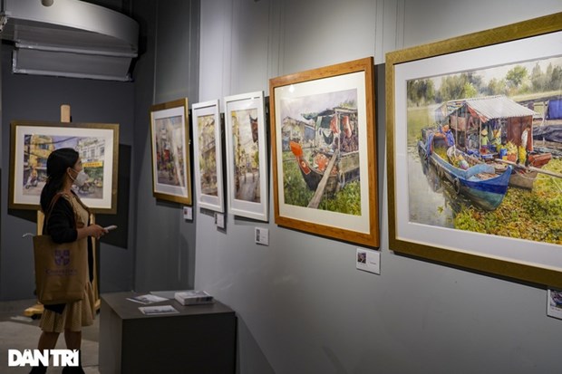 A visitor takes a look at the exhibited paintings. (Photo: dantri.com.vn)