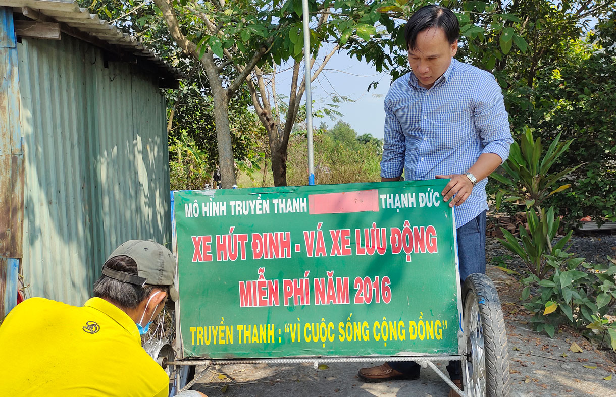 Anh Nguyễn Lê Duy (người đứng) cùng anh Phi Văn Tiến chăm sóc xe hút đinh để lên đường làm "nhiệm vụ" (Ảnh tư liệu)