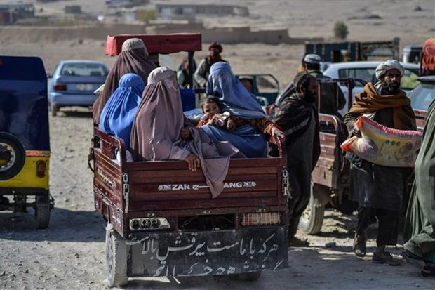 Người dân nhận thực phẩm cứu trợ của Hội chữ thập Đỏ ở Kandahar, Afghanistan. (Ảnh: AFP/TTXVN)