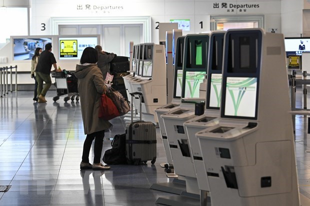 Hành khách làm thủ tục tại sân bay Haneda ở thủ đô Tokyo, Nhật Bản, ngày 1/12/2021. (Ảnh: AFP/TTXVN)