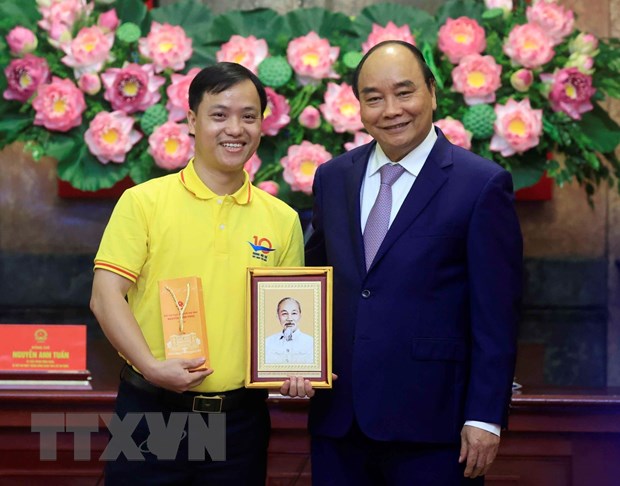 Chủ tịch nước Nguyễn Xuân Phúc tặng chân dung Chủ tịch Hồ Chí Minh cho đoàn viên thanh niên tiêu biểu. (Ảnh: Thống Nhất/TTXVN)