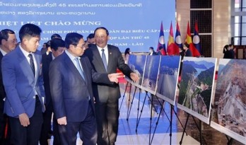 PMs of Vietnam, Laos visit photo exhibition on achievements of economic ties