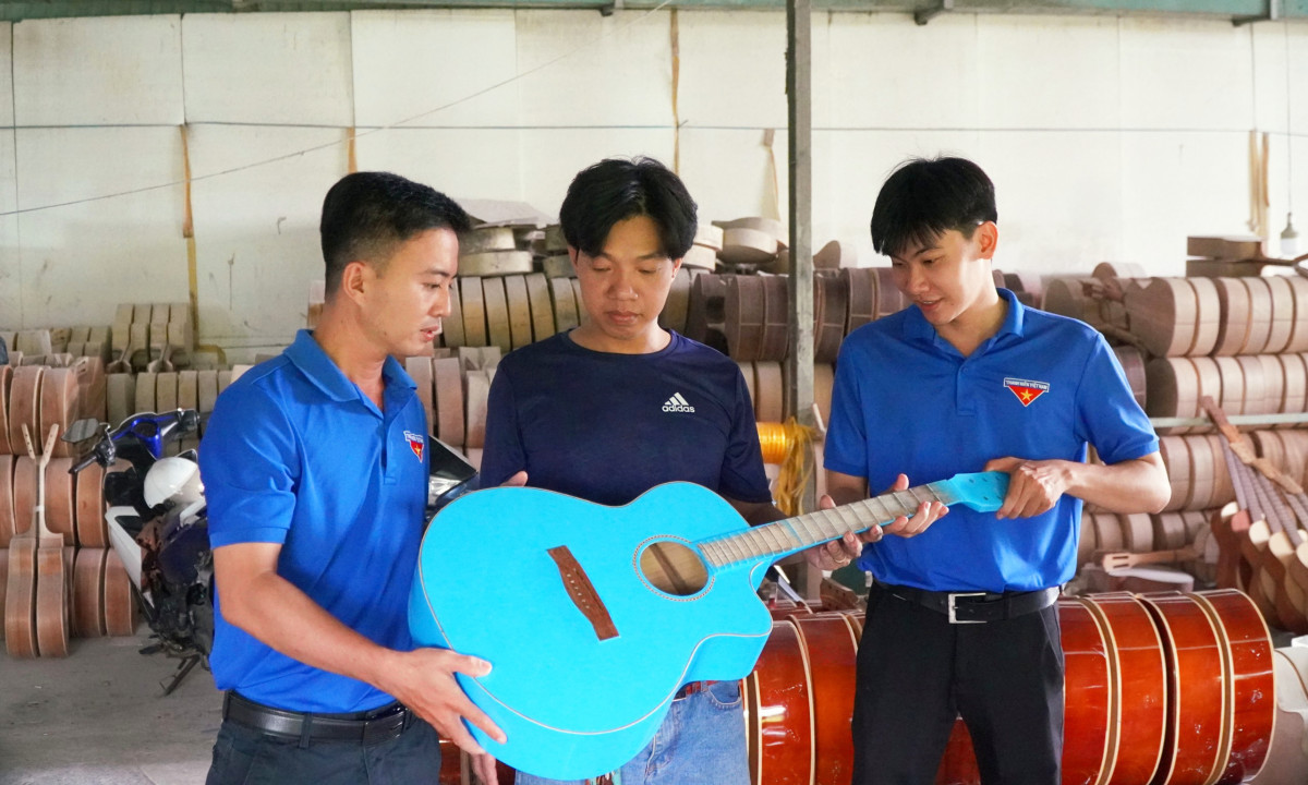 Anh Đào Văn Tươi (đứng giữa, ấp Thuận Tây 1, xã Thuận Thành, huyện Cần Giuộc) khởi nghiệp với nghề gia công guitar