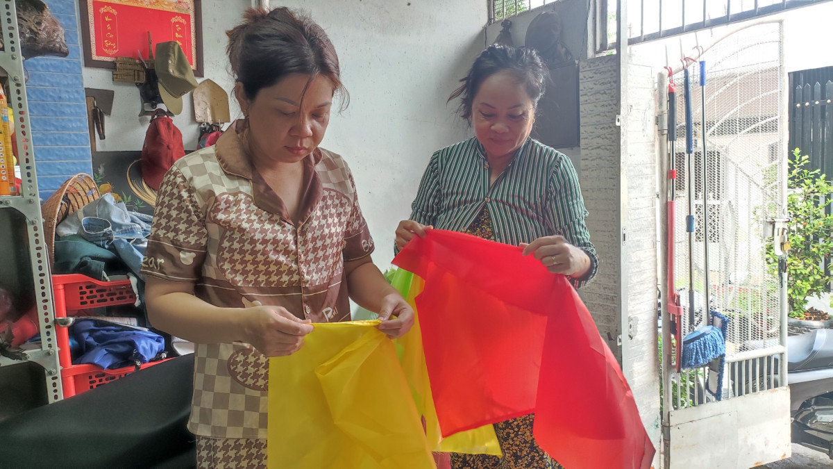 Chị Trương Thị Phượng Hoàng (bên trái) tạo điều kiện cho chị em phụ nữ nhận hàng về nhà làm để vừa có thêm thu nhập, vừa chăm lo gia đình