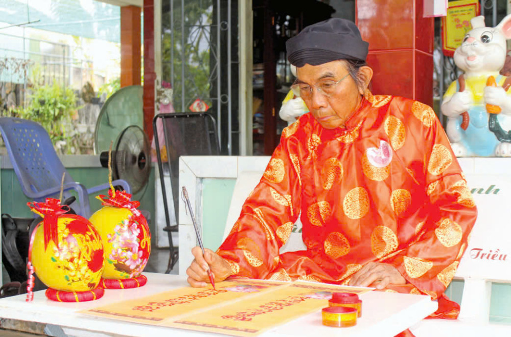 Thầy Huỳnh Long (phường Khánh Hậu, TP.Tân An) chăm chú viết chữ thư pháp trên tấm giấy đỏ, từng đường nét đều toát lên sự tinh tế và điêu luyện